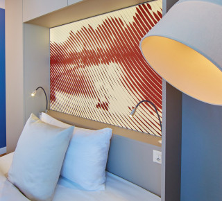 Lampe und Bett im Comfort Zimmer vom Hotel Wettstein